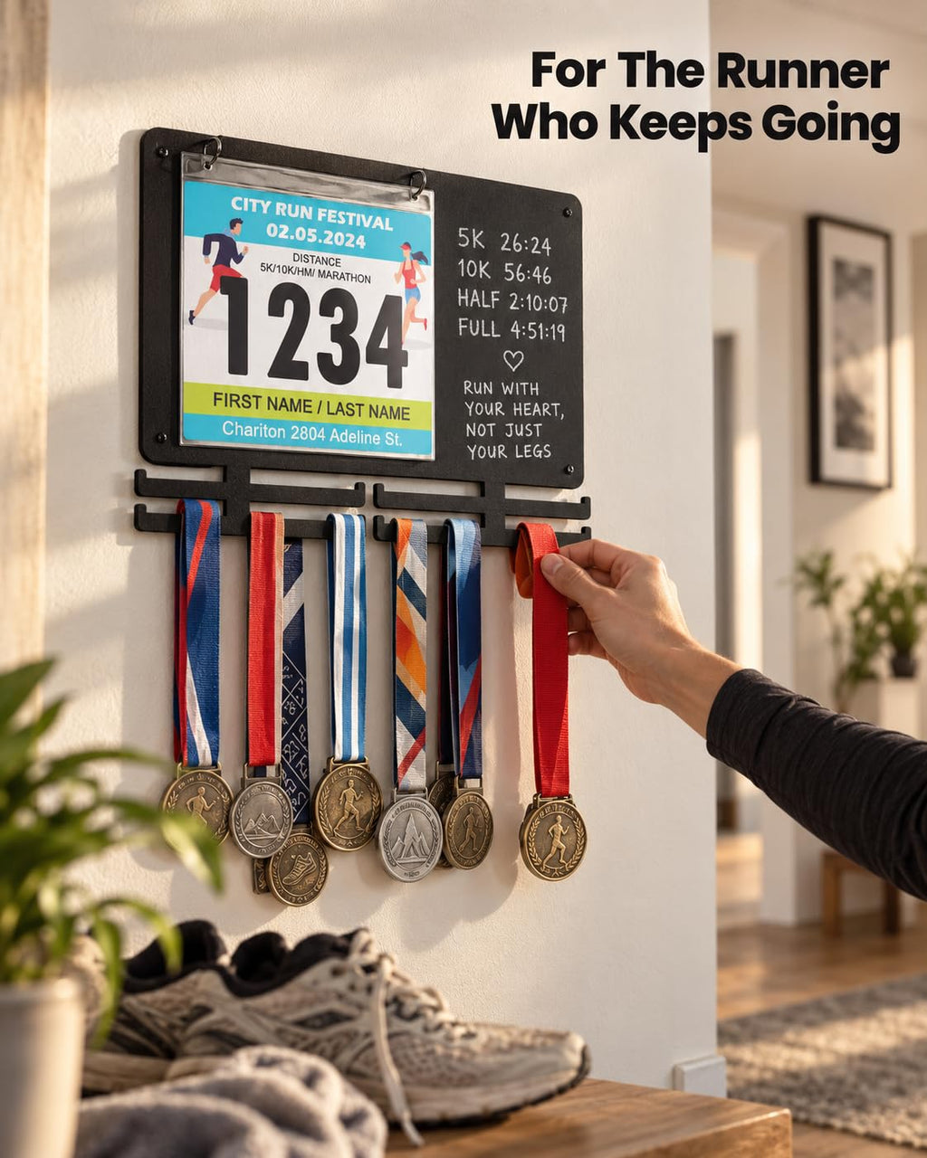 Runner hanging a new medal on the BLAUBECK medal and bib display mounted on a home wall