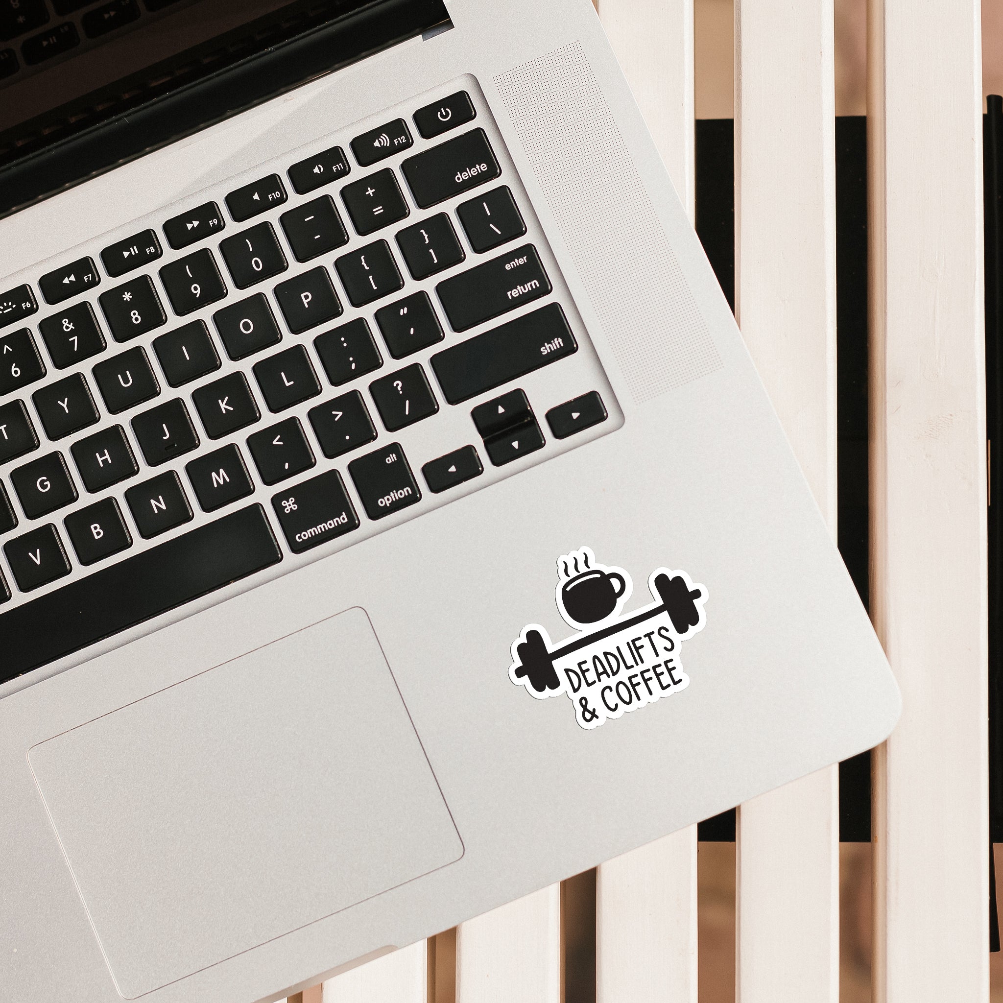 BLAUBECK Deadlifts and Coffee vinyl sticker placed on a MacBook trackpad